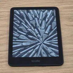 Une liseuse Kindle affiche une image abstraite de plumes d'encre. Parfait pour une pause thé et lecture.