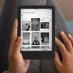 Une personne tient un Kindle affichant des livres, une invitation à découvrir un livre Kindle gratuit.