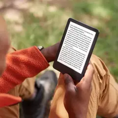 Un homme lit sur sa liseuse, profitant du plein air. Il a peut-être converti des fichiers azw to epub pour une lecture nomade.