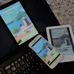 Un ordinateur portable, un smartphone et un **kindle audio** affichent un guide numérique sur le Monténégro et Dubrovnik.