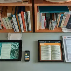 Des livres sur une étagère, une tablette affichant un livre numérique et un smartphone. Qu'est-ce que le format Kindle pour un livre ? C'est un livre électronique.