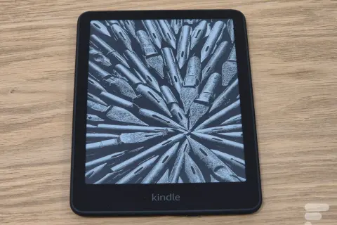 Une liseuse Kindle affiche une image abstraite de plumes d'encre. Parfait pour une pause thé et lecture.