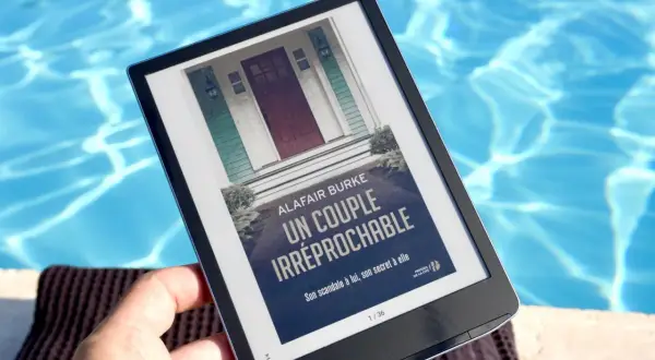 Une liseuse e-ink affiche "Un couple irréprochable" au bord d'une piscine.
