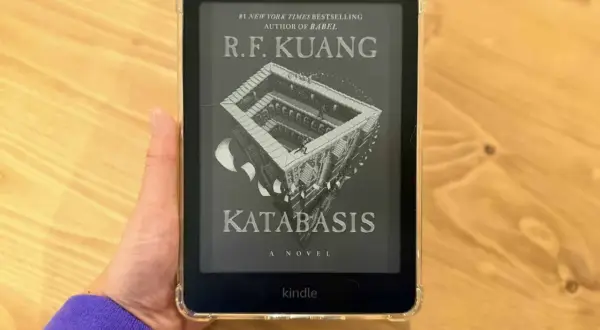 Main d'une personne tenant un Kindle Paperwhite affichant la couverture du livre "Katabasis" de R.F. Kuang.