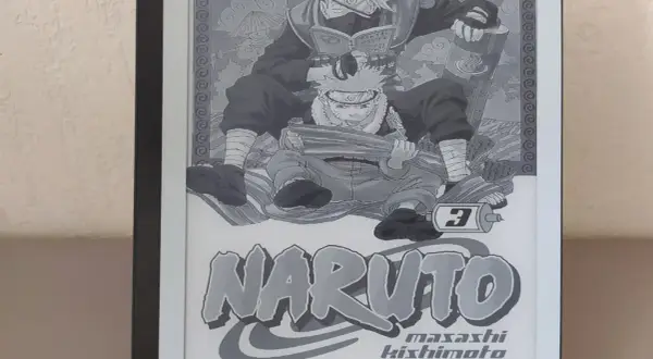 Un **manga sur liseuse** affiche la couverture du tome 3 de Naruto, avec Kakashi lisant par-dessus Naruto.
