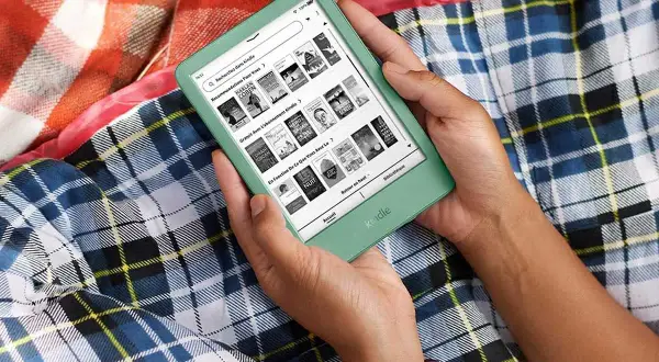 Une personne tient une liseuse verte affichant des recommandations de livres, y compris des titres gratuits avec abonnement. Parfait pour lire confortablement.