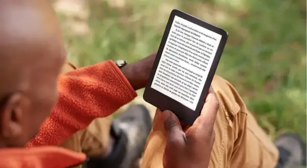 Un homme lit sur sa liseuse, profitant du plein air. Il a peut-être converti des fichiers azw to epub pour une lecture nomade.