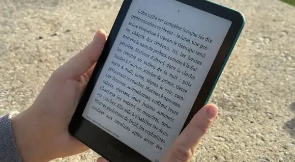 Une personne lit un livre sur une liseuse Kindle. Apprenez comment prêter un livre Kindle à un ami.