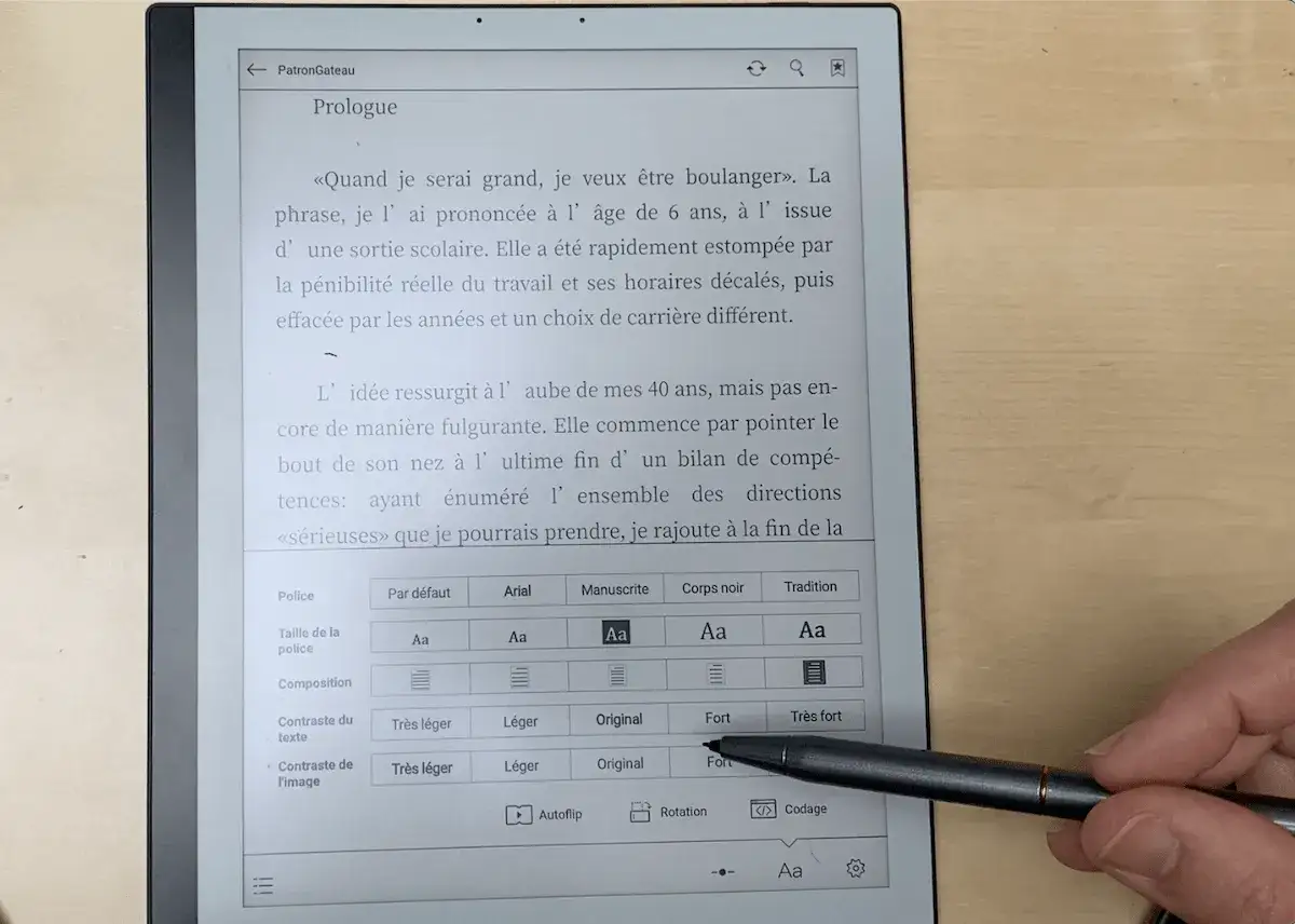 Un stylet effleure l'&eacute;cran d'une liseuse Bookeen Notea, affichant un texte et des options de mise en forme.