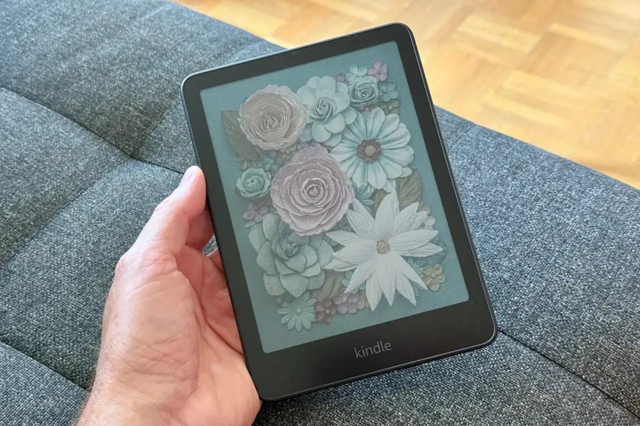 Main tenant une liseuse Kindle avec un &eacute;cran affichant un bouquet de fleurs stylis&eacute;es. Ce visuel peut servir de guide pour le kindle mode d'emploi.