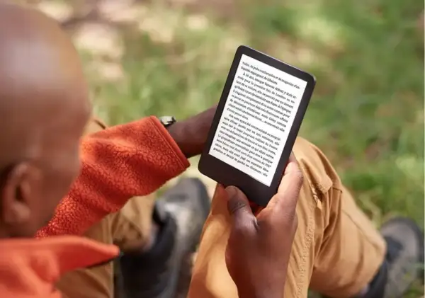 Un homme lit sur sa liseuse, profitant du plein air. Il a peut-être converti des fichiers azw to epub pour une lecture nomade.