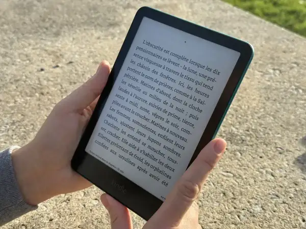 Une personne lit un livre sur une liseuse Kindle. Apprenez comment prêter un livre Kindle à un ami.